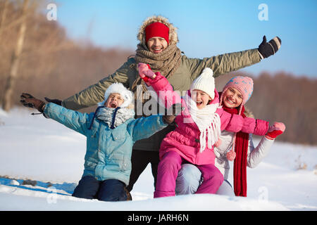 Heureux les parents et leurs enfants en s'amusant winterwear en dehors Banque D'Images