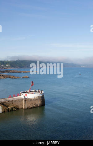 Sea mist rolls dans de l'étranger à travers les falaises du sud-est de Cornwall avec le banjo pier de la ville balnéaire de Looe, Cornwall, dans l'avant-plan Banque D'Images