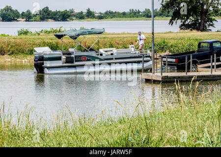 Un homme de race blanche des charges jusqu'un bateau ponton sur un bateau remorque après la pêche sur le lac Overholser à Oklahoma City, Oklahoma, USA. Banque D'Images