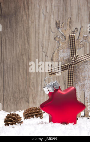 Weihnachten, Dekoration mit Schnee, Weihnachtskugeln Holzhintergrund, rot, Tannenzapfen und Elch Banque D'Images