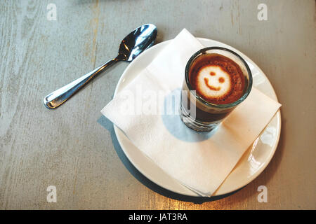 Le café dans un verre, avec un smiley sur le dessus. Nice. Banque D'Images