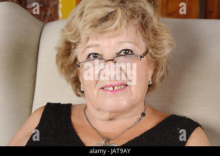 Portrait d'une vieille femme assise sur le canapé. À l'intérieur. Banque D'Images