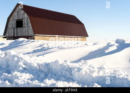 Vieille grange abandonnée en ruine et recouverts de neige en plein jour Banque D'Images