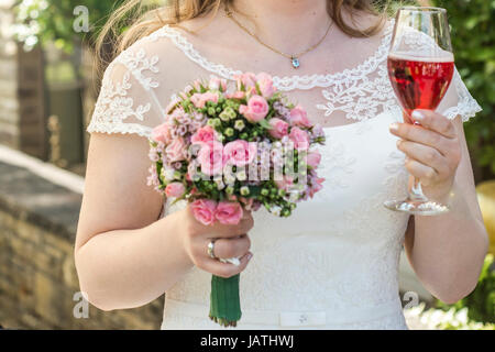 Bride holding a bouquet de fleurs et un verre de vin de mariage mariage gros plan Banque D'Images