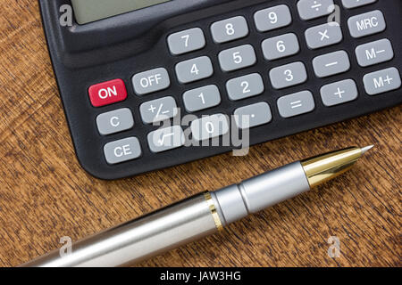 L'ajout des chiffres concept avec calculatrice moderne et un stylo sur la table Banque D'Images