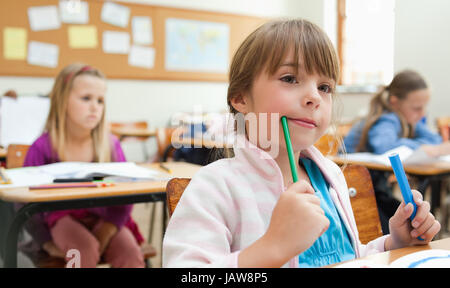 Une petite fille assise dans la première rangée de la classe Banque D'Images