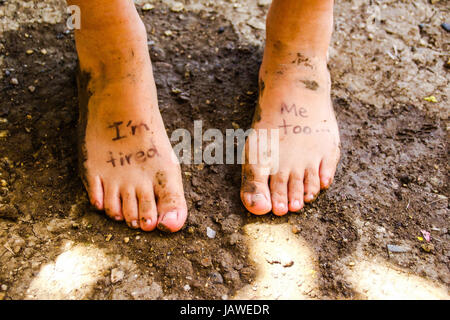Photographie d'une paire de pieds humains et de l'expression : Im fatigué, moi aussi Banque D'Images