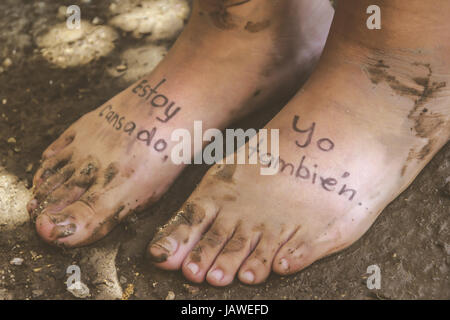 Photographie d'une paire de pieds humains et de la phrase en espagnol : Estoy cansado, yo tambien, ce qui signifie : Im fatigué, moi aussi Banque D'Images