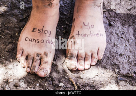 Photographie d'une paire de pieds humains et de la phrase en espagnol : Estoy cansado, yo tambien, ce qui signifie : Im fatigué, moi aussi Banque D'Images