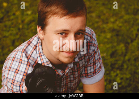 Happy young man holding camera prendre des photos photographe Banque D'Images