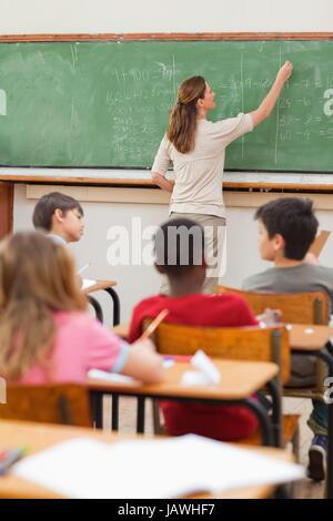 Problèmes de maths Teacher writing on blackboard Banque D'Images