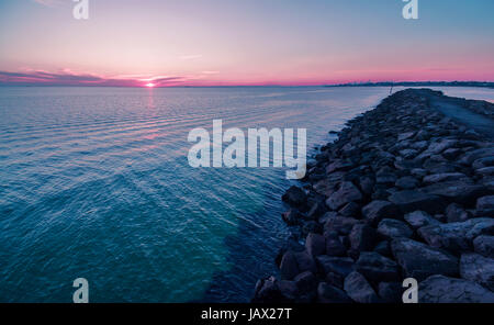 Vue aérienne de magnifique coucher de soleil sur l'eau et des brise-lames Banque D'Images