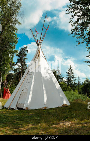 Un tipi (également tepee et tipi) est une tente conique, traditionnellement faites de peaux d'animaux, et de bâton contre le ciel bleu Banque D'Images