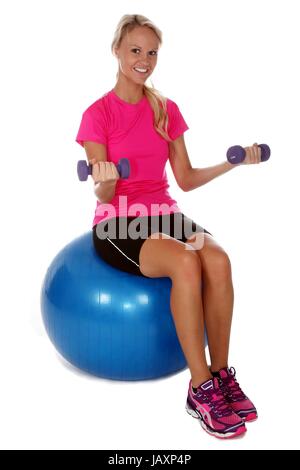 Belle jeune fille faisant des exercices de gymnastique sur une balle de caoutchouc gonflé Banque D'Images