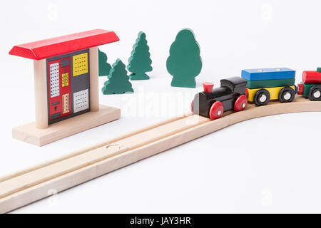 Toy ticket machine à voie de chemin de fer en bois avec quelques arbres en arrière-plan Banque D'Images