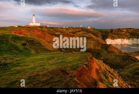 Les conditions météorologiques et l'érosion de la mer le long de la côte nord-est avec vue sur le phare au lever du soleil en été à Flamborough Head, Yorkshire, UK. Banque D'Images