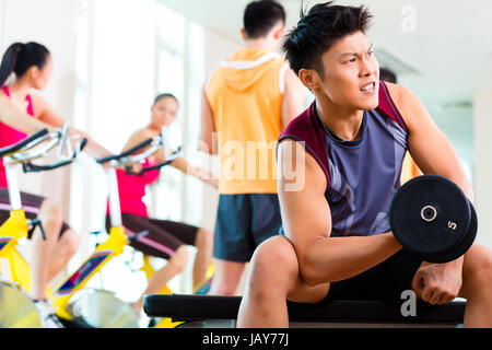 Groupe asiatique chinois de l'homme et de la femme faire du sport ou d'exercice de formation de remise en forme avec des poids et haltères pour plus de puissance Banque D'Images