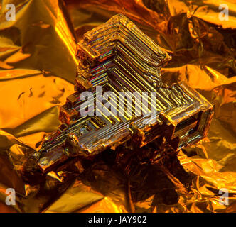 Un cristal Bismuth multicolores, chaud illuminée en retour d'or Banque D'Images