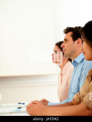 Portrait des gens d'affaires à l'écoute au cours d'une conférence tout en restant assis sur le lieu de travail Banque D'Images