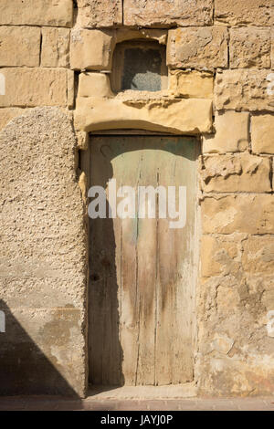 Une vieille porte sur un bâtiment en pierre dans le port de pêche de Marsaxlokk à Malte. Un détail architectural avec la peinture verte pâle Banque D'Images