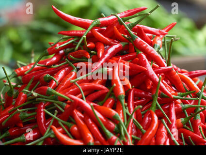 Piments rouges frais close up avec le poivron vert dans l'arrière-plan blured. Ingrédients de cuisson. Banque D'Images