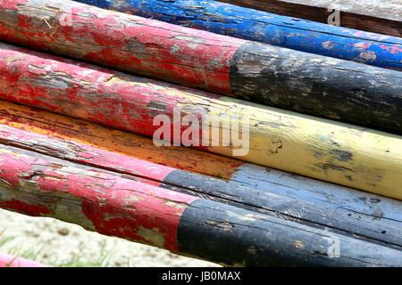 Image de couleur multi pôles cso empilées dans l'arène de saut. Les barrières en bois ancienne rétro sur le terrain pour chevaux comme un backgroun Banque D'Images