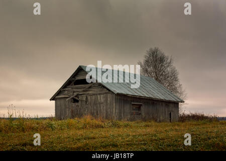 Une vieille grange maison se trouve sur le champs d'automne du nord de la Finlande. L'automne est là et le travail sur le terrain est terminé. Banque D'Images