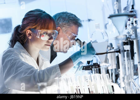 Soins de santé les chercheurs travaillant en laboratoire de sciences de la vie. Jeune femme chercheur scientifique principal et superviseur de la préparation et de l'analyse de microsc Banque D'Images