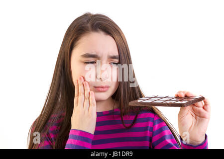 Petite fille avec mal de dents parce que son chocolat mange Banque D'Images