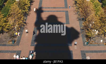 Liberty Island, NY - Octobre 1990 : Les visiteurs marchent au milieu d'ombre de la Statue de la liberté et les feuilles d'automne Banque D'Images