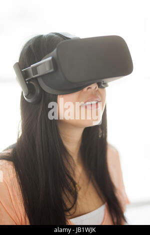 Young Asian woman wearing casque de réalité virtuelle oculus rift et démontrer comment utiliser la commande tactile Banque D'Images