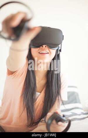 Young Asian woman wearing casque de réalité virtuelle oculus rift et démontrer comment utiliser la commande tactile Banque D'Images