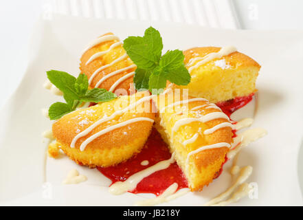 Crème anglaise muffins rempli avec sauce aux framboises Banque D'Images