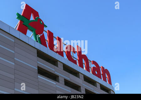 Cracovie, Pologne - 03 juin 2017 : Signe de l'hypermarché Auchan sur le ciel bleu dans une journée ensoleillée. Auchan est un hypermarke distribution international français Banque D'Images