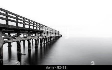 Une longue exposition d'un ancien pont de plage - la plage de Kep Cambodge - pont ruine en noir et blanc Banque D'Images