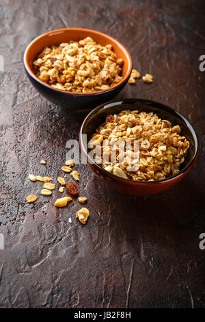 Délicieux muesli muesli fait maison ou dans deux bols de céramique sur fond de pierre. Banque D'Images