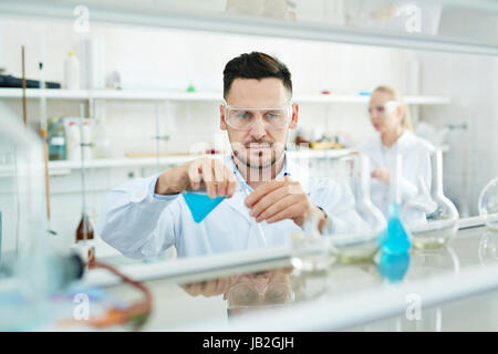 Chercheur moderne travaillant en laboratoire avec des tubes à essai et réagir Banque D'Images