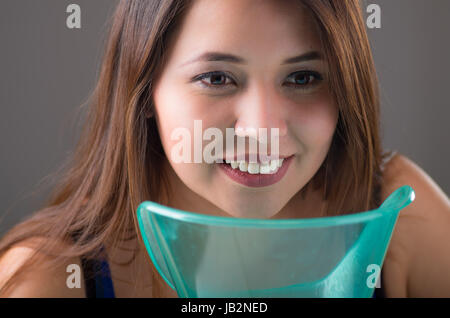Jeune femme faisant l'inhalation avec un vaporisateur médical machine nébuliseur sur fond gris. Banque D'Images