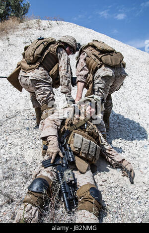 Les marines américains évacuer les blessés en armes dans les montagnes Banque D'Images