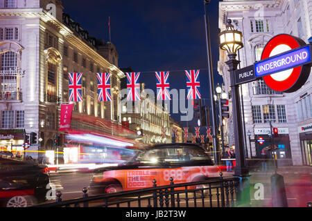 Picadilly Circus touristique populaire avec des drapeaux Union Jack à l'allumage des feux de nuit à Londres, Angleterre, Royaume-Uni Banque D'Images