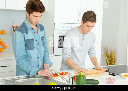 Trois amis pizza dans la cuisine ensemble Banque D'Images