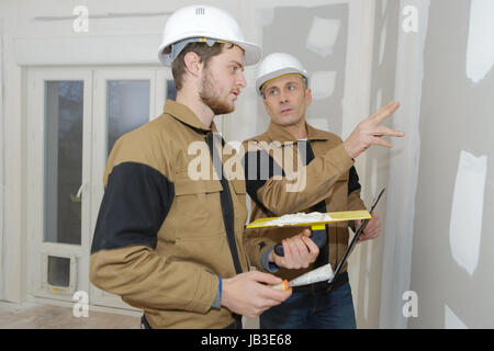 Construction Worker wearing dans l'ensemble des travailleurs avec wall plastering tools Banque D'Images