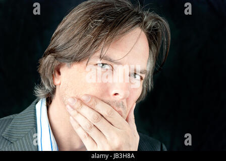 Close-up of a businessman mauvais couvrant sa bouche. Banque D'Images