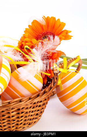Traditionnelle bemalte bunte ostereier mit orangen karte frohe ostern dekoration gerbera isoliert textfreiraum Banque D'Images