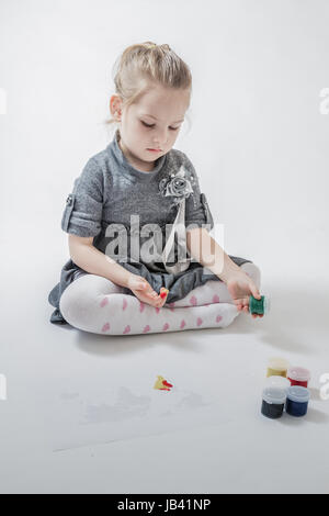 Peu cute girl painting la carte du monde avec la peinture de doigt Banque D'Images