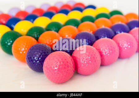 Rangées de balles de mini-golf colorés sur fond blanc Banque D'Images