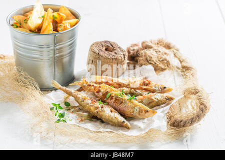 Une odeur de poisson et frites aux herbes sur fond blanc Banque D'Images