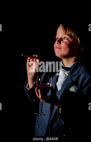 Garçon en smoking, avec verre de vin rouge et d'un cigare Banque D'Images