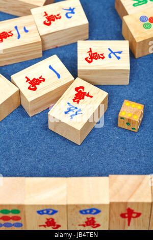 Tuiles en bois dans mahjong pendant la lecture sur table en tissu bleu close up Banque D'Images