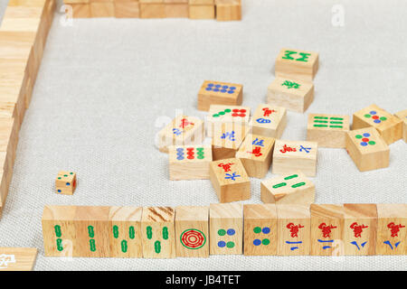 Main du Joueur de tuiles en bois de mahjong sur table textile Banque D'Images